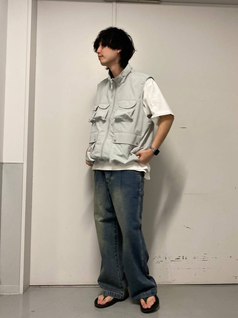 ブルー系のデニムパンツ、ブラック系のサンダル、ホワイト系のTシャツ/カットソーを着用したメンズの夏コーディネートの2枚目の写真