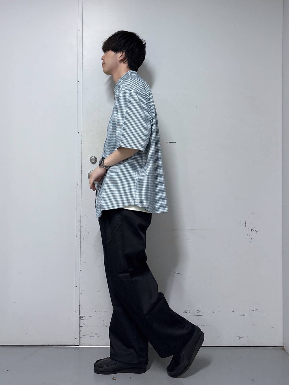 ブラック系のチノパンツ、ホワイト系のシャツ/ブラウス、ホワイト系のタンクトップを着用したメンズの春コーディネートの2枚目の写真