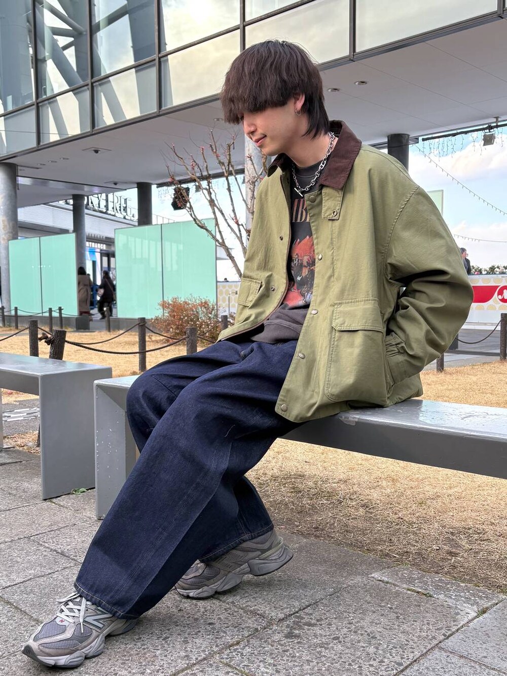 グリーン系のブルゾン、ブルー系のデニムパンツ、ブラック系のスウェットを着用したメンズの冬コーディネートの2枚目の写真