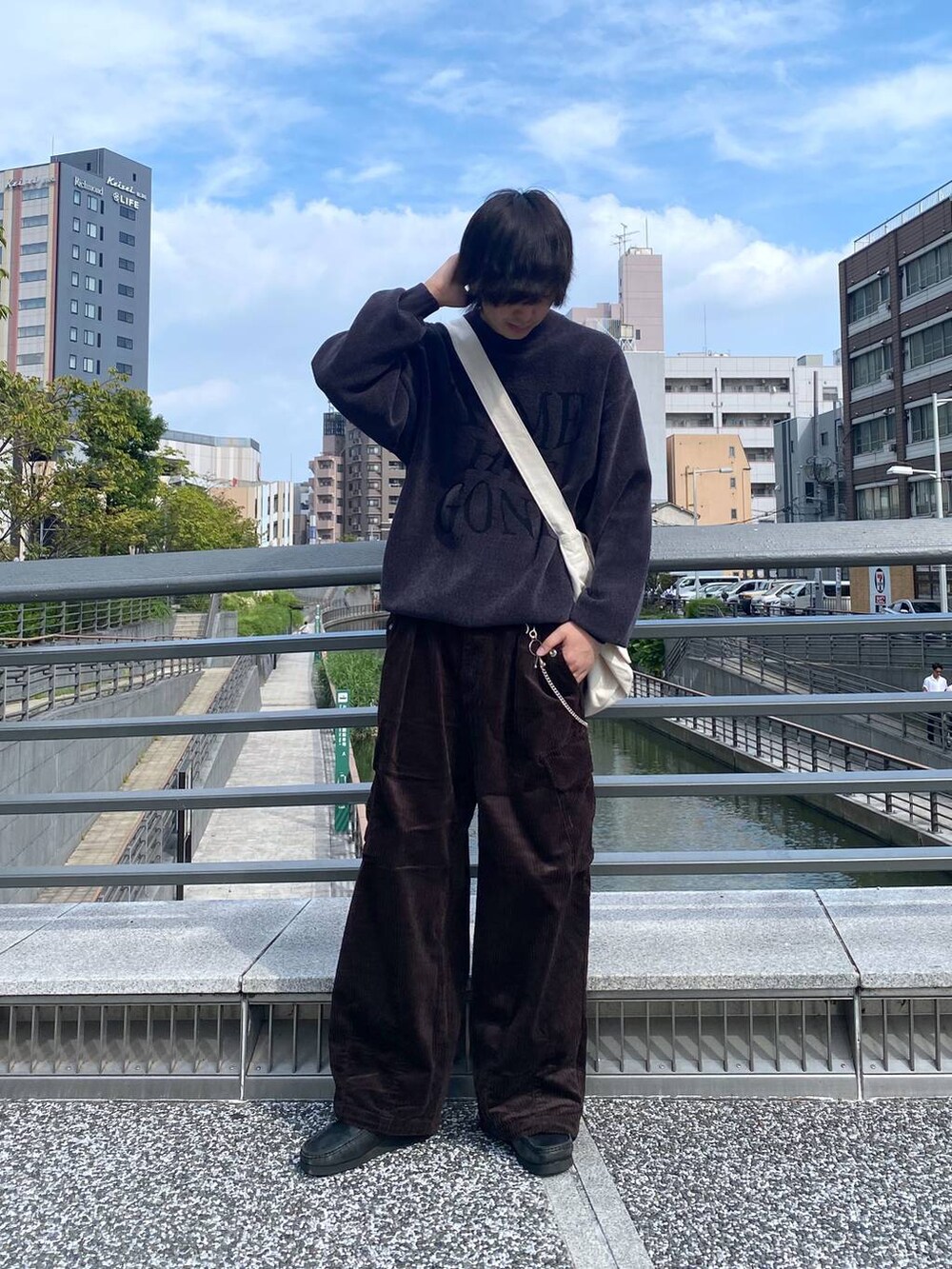 ブラウン系のカーゴパンツ、ホワイト系のショルダーバッグ、グレー系のニット/セーターを着用したメンズの秋コーディネートの2枚目の写真