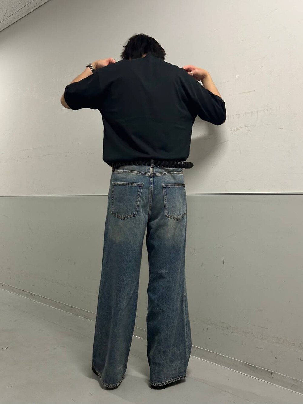 ブルー系のデニムパンツ、ブラック系のTシャツ/カットソー、ブラック系のベルトを着用したメンズの夏コーディネートの3枚目の写真