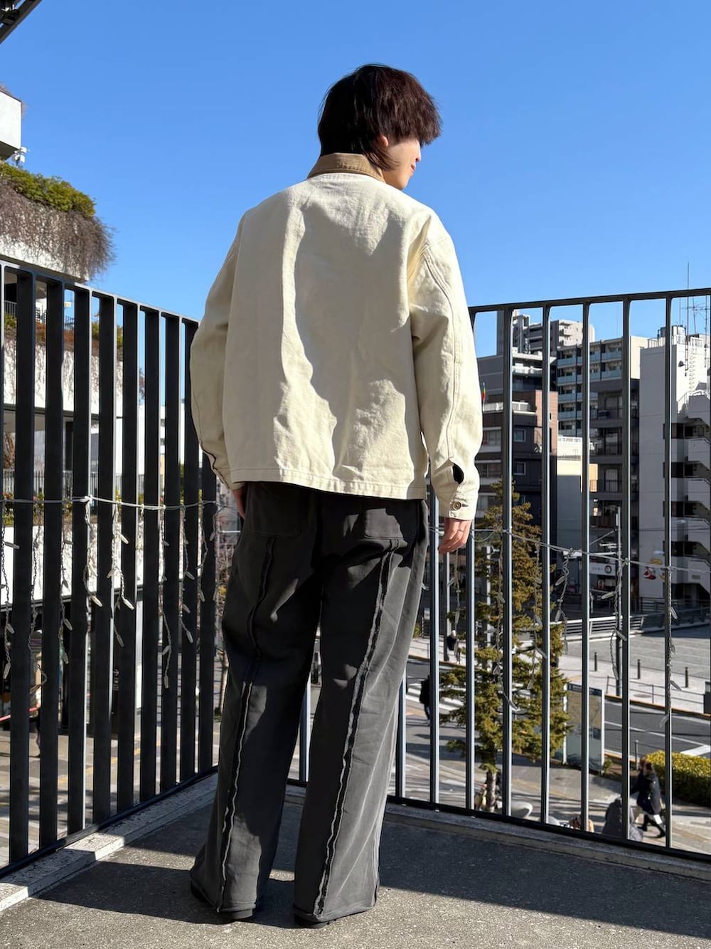ホワイト系のデニムジャケット、ブラック系のドレスシューズ、ブラック系のスウェットを着用したメンズの冬コーディネートの2枚目の写真