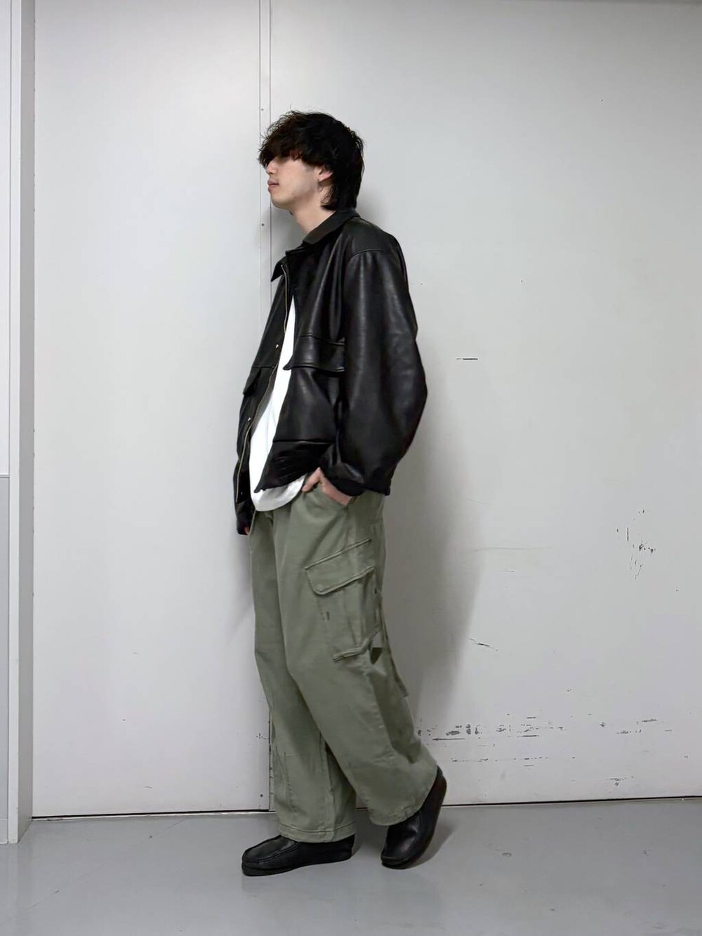 ブラック系のブルゾン、グリーン系のカーゴパンツ、ホワイト系のTシャツ/カットソーを着用したメンズの春コーディネートの2枚目の写真