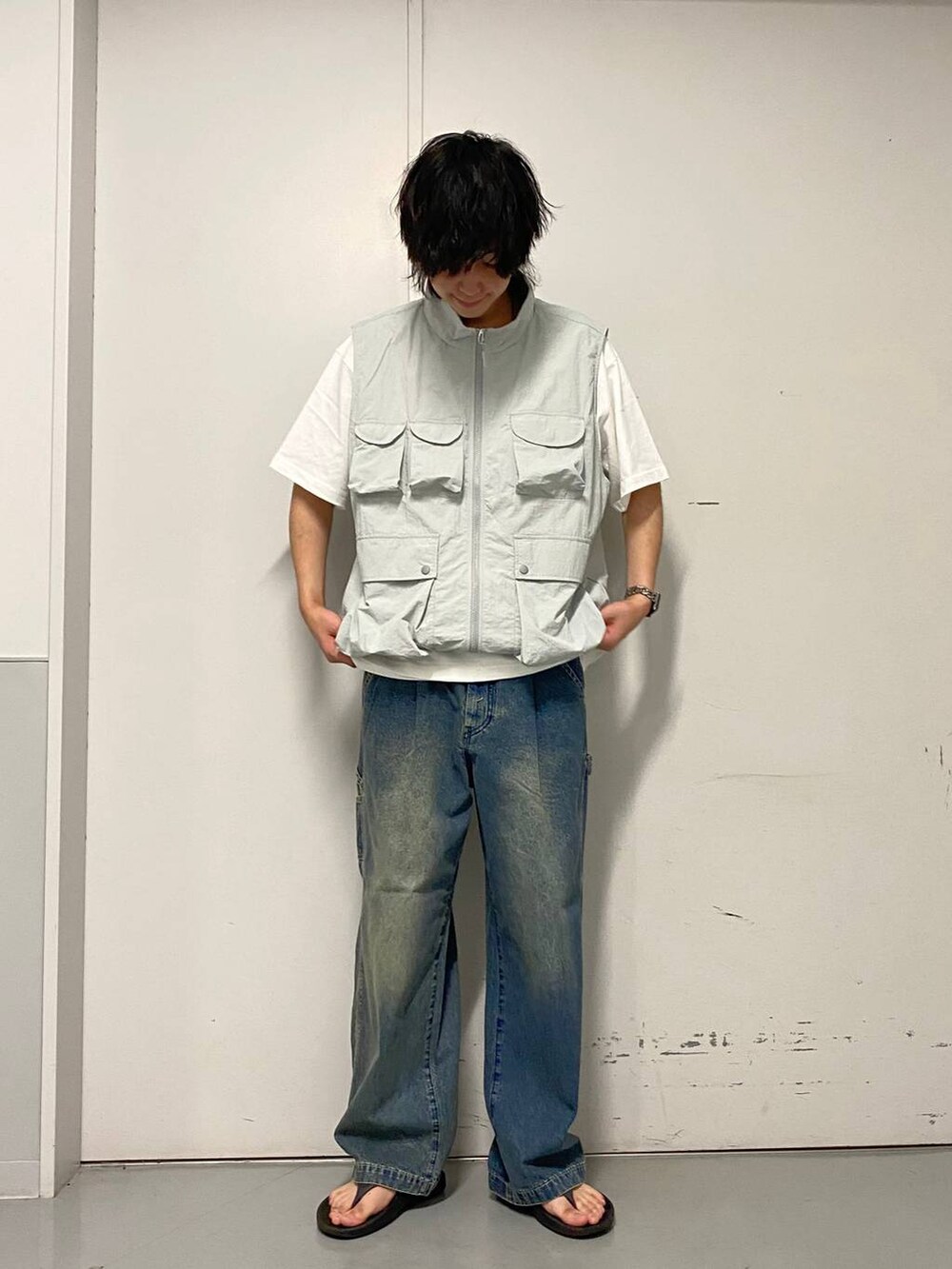 ブルー系のデニムパンツ、ブラック系のサンダル、ホワイト系のTシャツ/カットソーを着用したメンズの夏コーディネートの3枚目の写真