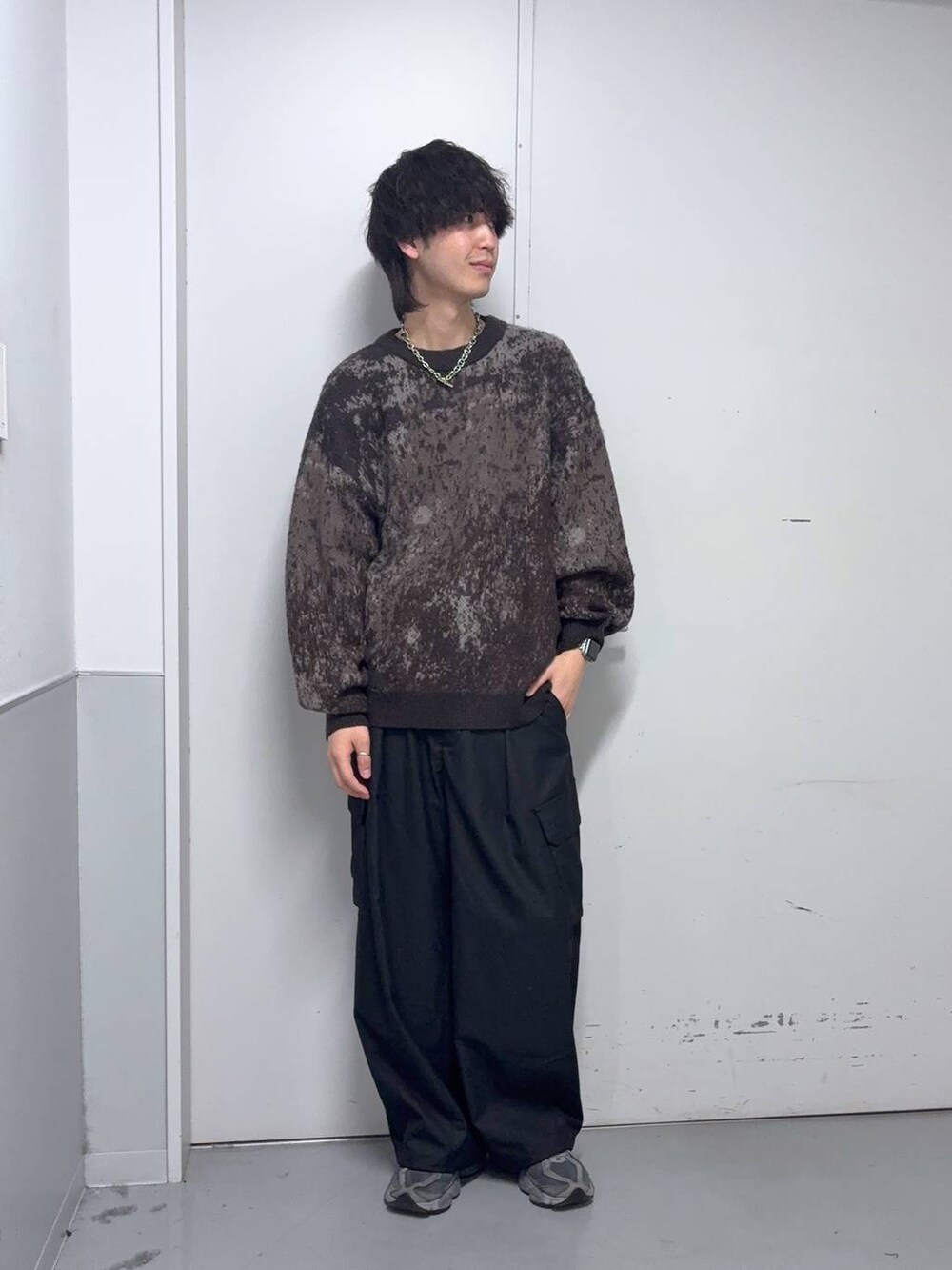 ブラウン系のニット/セーター、ブラック系のスラックス、ブルー系のソックス/靴下を着用したメンズの冬コーディネートの5枚目の写真