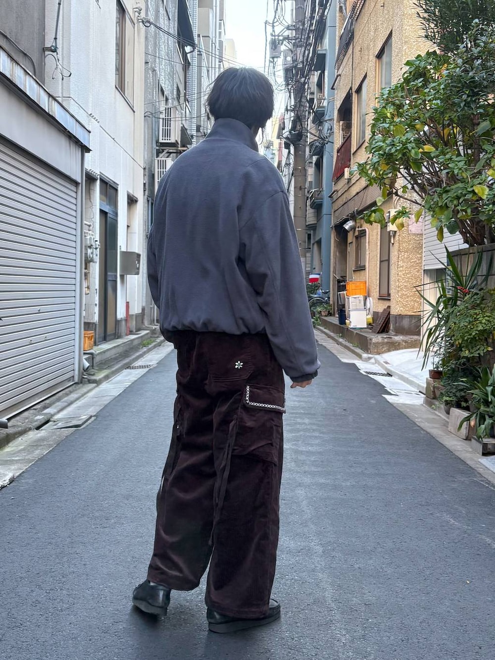 グレー系のブルゾン、ブラック系のニット/セーター、ブラウン系のカーゴパンツを着用したメンズの冬コーディネートの2枚目の写真