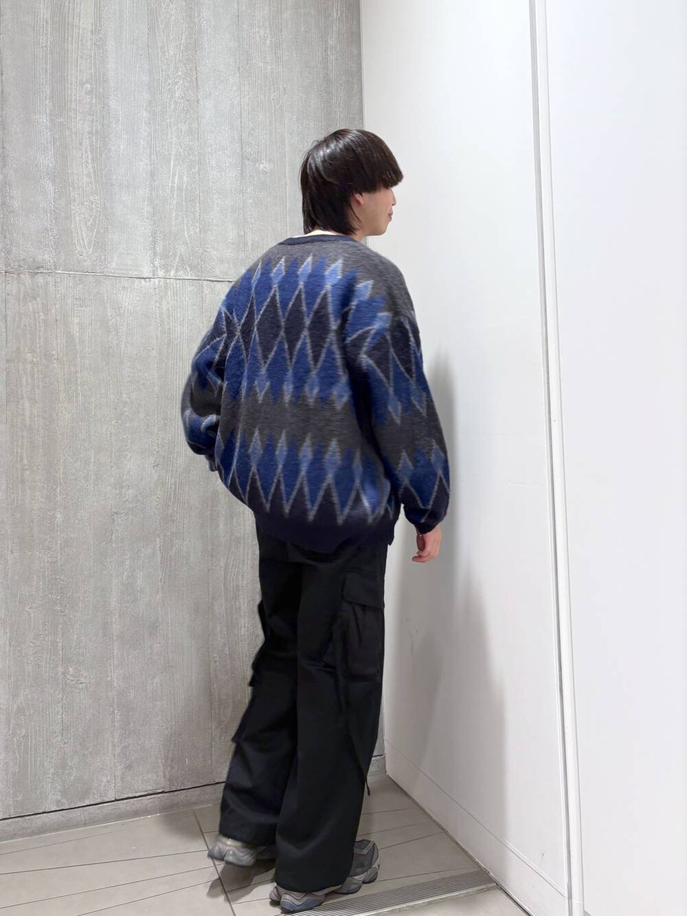 ブラック系のカーゴパンツ、ホワイト系のTシャツ/カットソー、ブルー系のカーディガン/ボレロを着用したメンズの秋コーディネートの2枚目の写真