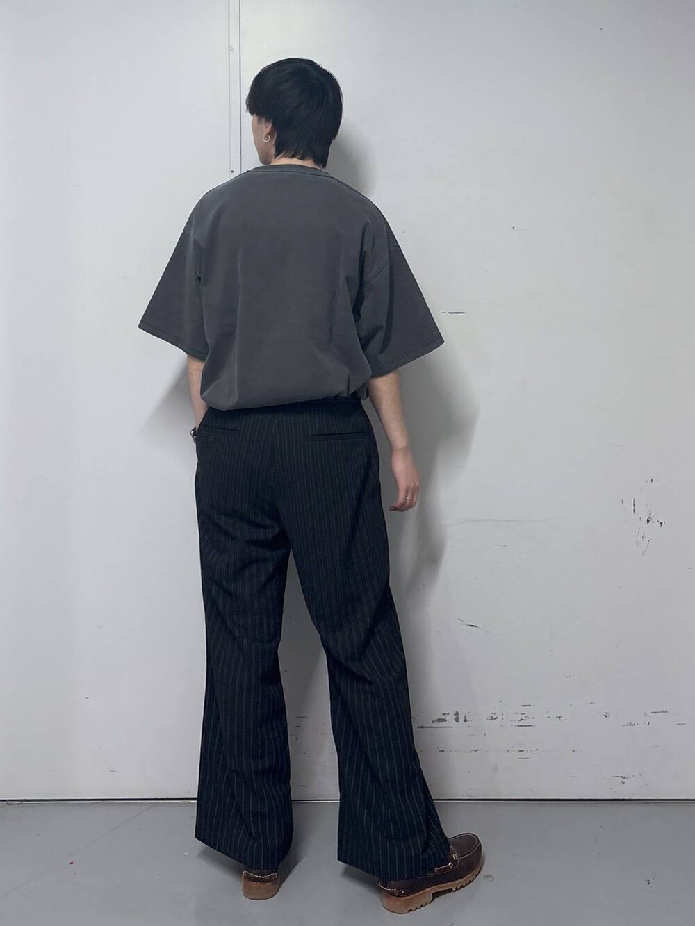 ブラック系のスラックス、グレー系のTシャツ/カットソー、ブラック系のベルトを着用したメンズの春コーディネートの3枚目の写真