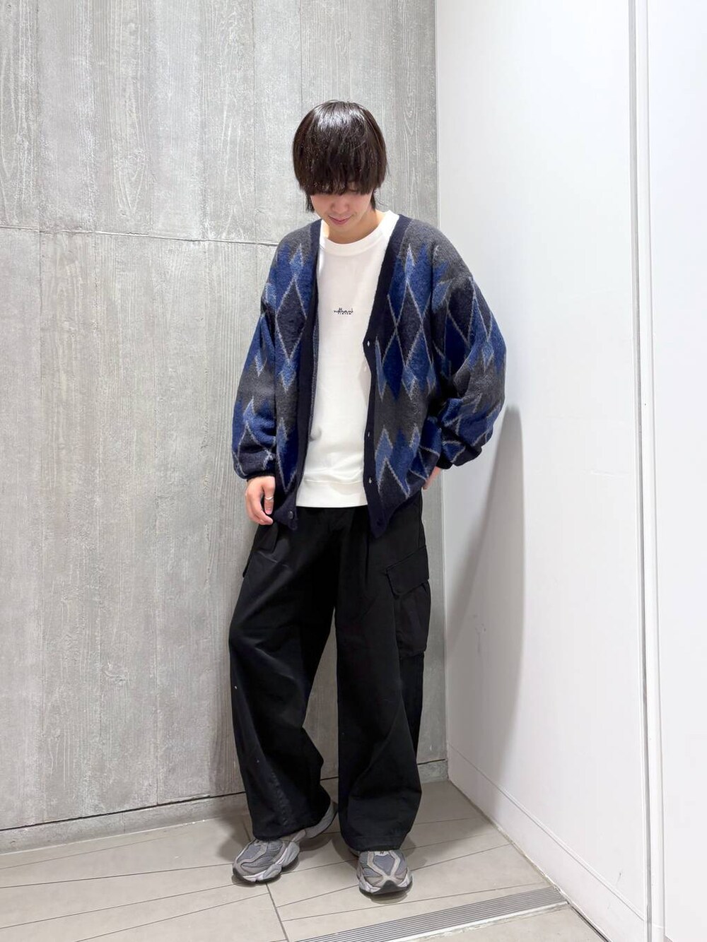 ブラック系のカーゴパンツ、ホワイト系のTシャツ/カットソー、ブルー系のカーディガン/ボレロを着用したメンズの秋コーディネートの3枚目の写真