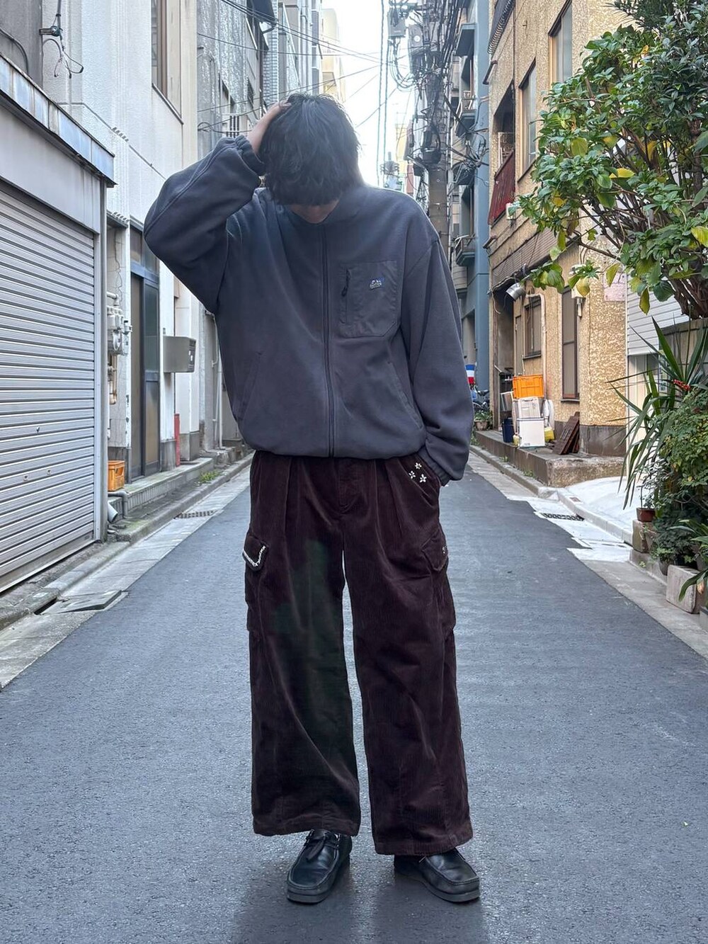 グレー系のブルゾン、ブラック系のニット/セーター、ブラウン系のカーゴパンツを着用したメンズの冬コーディネートの4枚目の写真