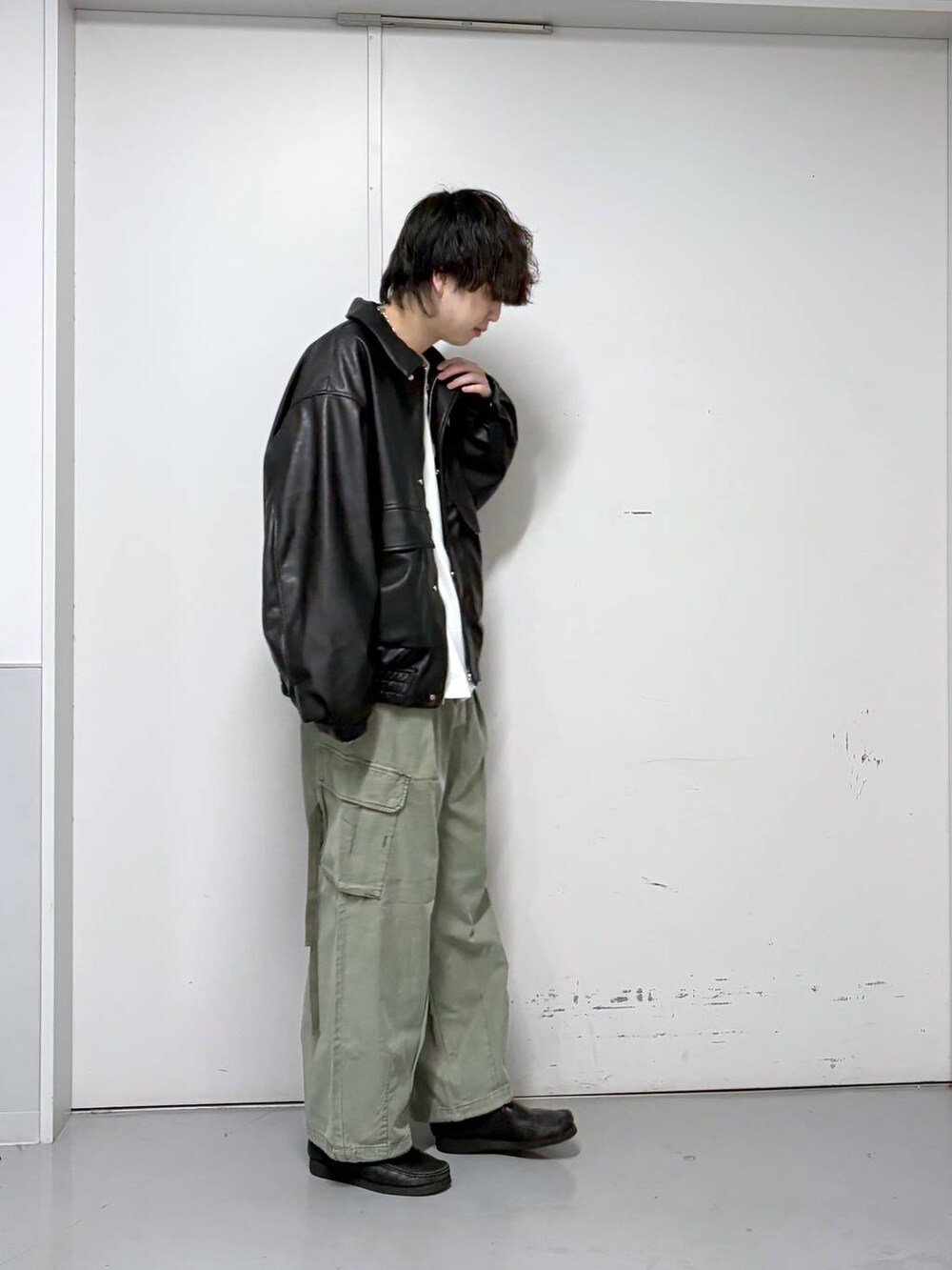 ブラック系のブルゾン、グリーン系のカーゴパンツ、ホワイト系のTシャツ/カットソーを着用したメンズの春コーディネートの4枚目の写真