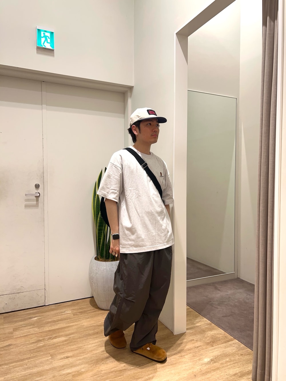 ブラック系のカーゴパンツ、ブラック系のショルダーバッグ、グレー系のTシャツ/カットソーを着用したメンズの夏コーディネートの2枚目の写真