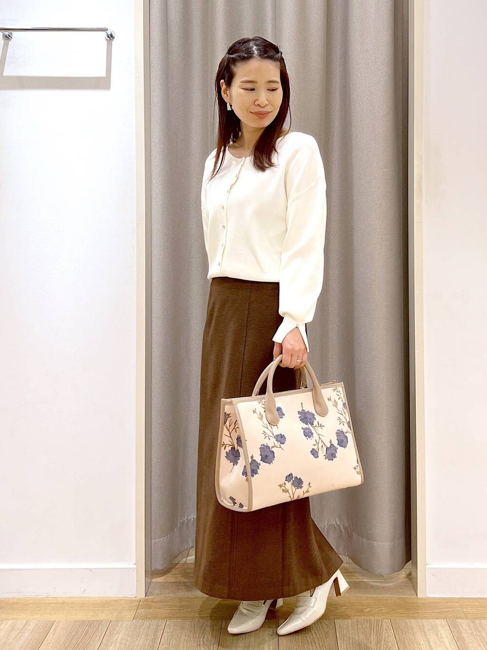 ベージュ系のローファー、ホワイト系のカーディガン/ボレロ、ブラウン系のスカートを着用したレディースの秋コーディネートの6枚目の写真