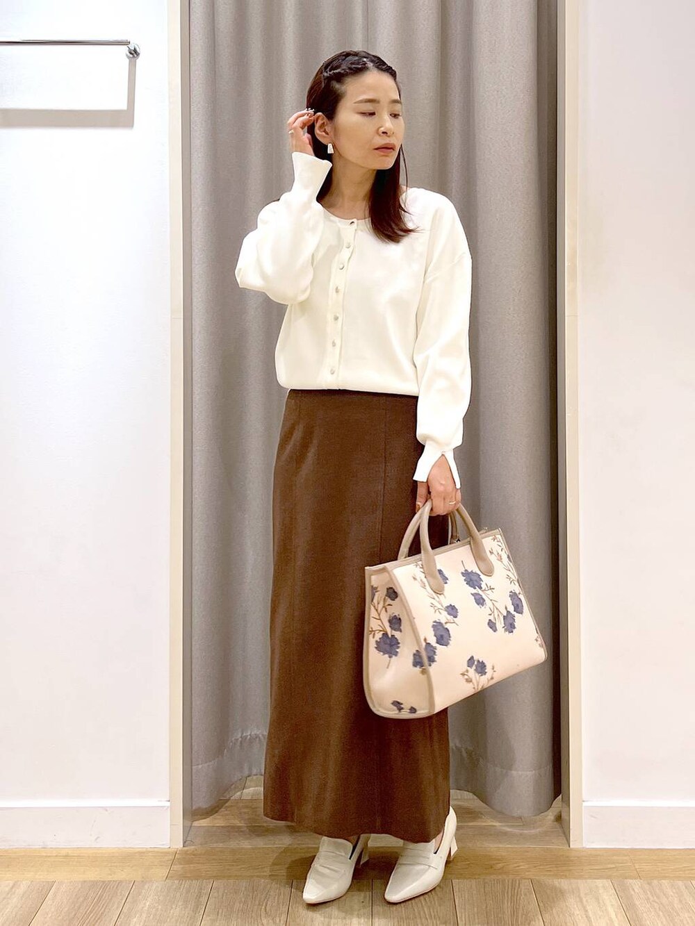 ベージュ系のローファー、ホワイト系のカーディガン/ボレロ、ブラウン系のスカートを着用したレディースの秋コーディネートの5枚目の写真