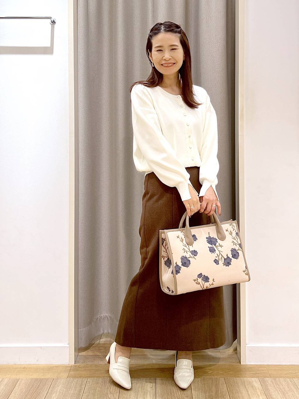 ベージュ系のローファー、ホワイト系のカーディガン/ボレロ、ブラウン系のスカートを着用したレディースの秋コーディネートの7枚目の写真