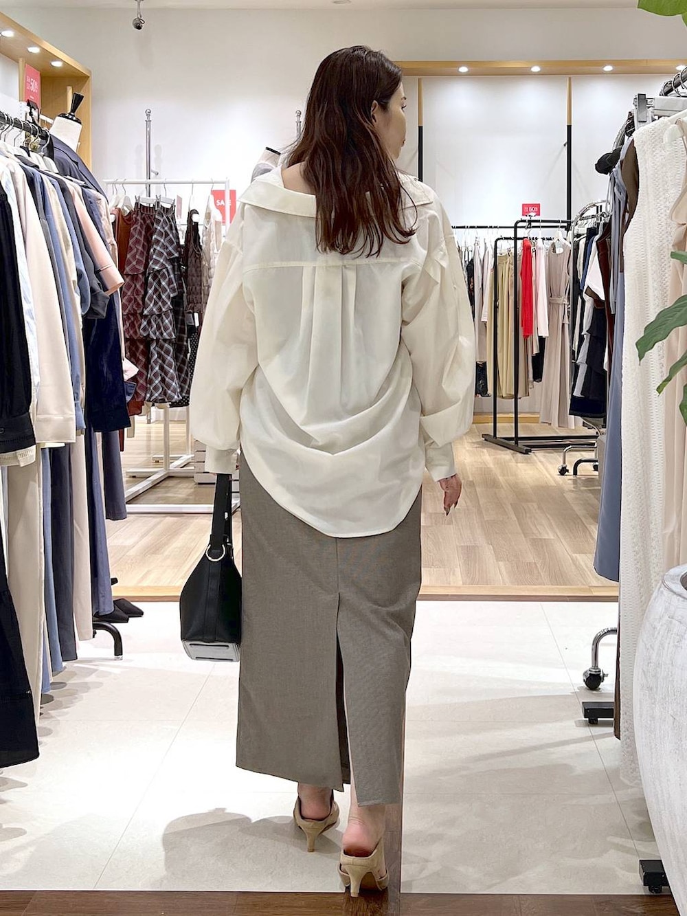 ベージュ系のスカート、ベージュ系のパンプス、ホワイト系のシャツ/ブラウスを着用したレディースの夏コーディネートの9枚目の写真