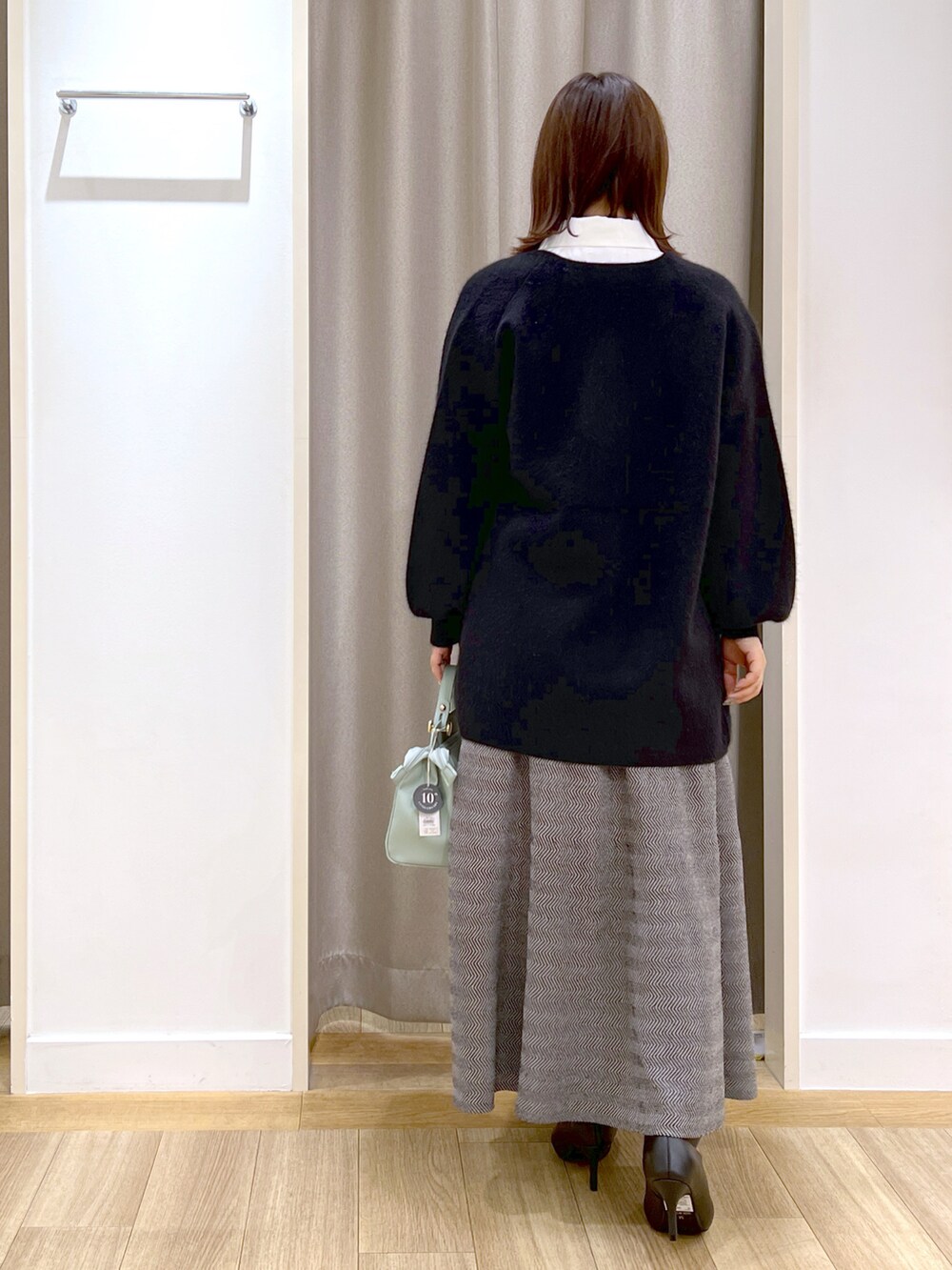 ブラック系のカーディガン/ボレロ、ブラック系のワンピース、グリーン系のショルダーバッグを着用したレディースの冬コーディネートの3枚目の写真