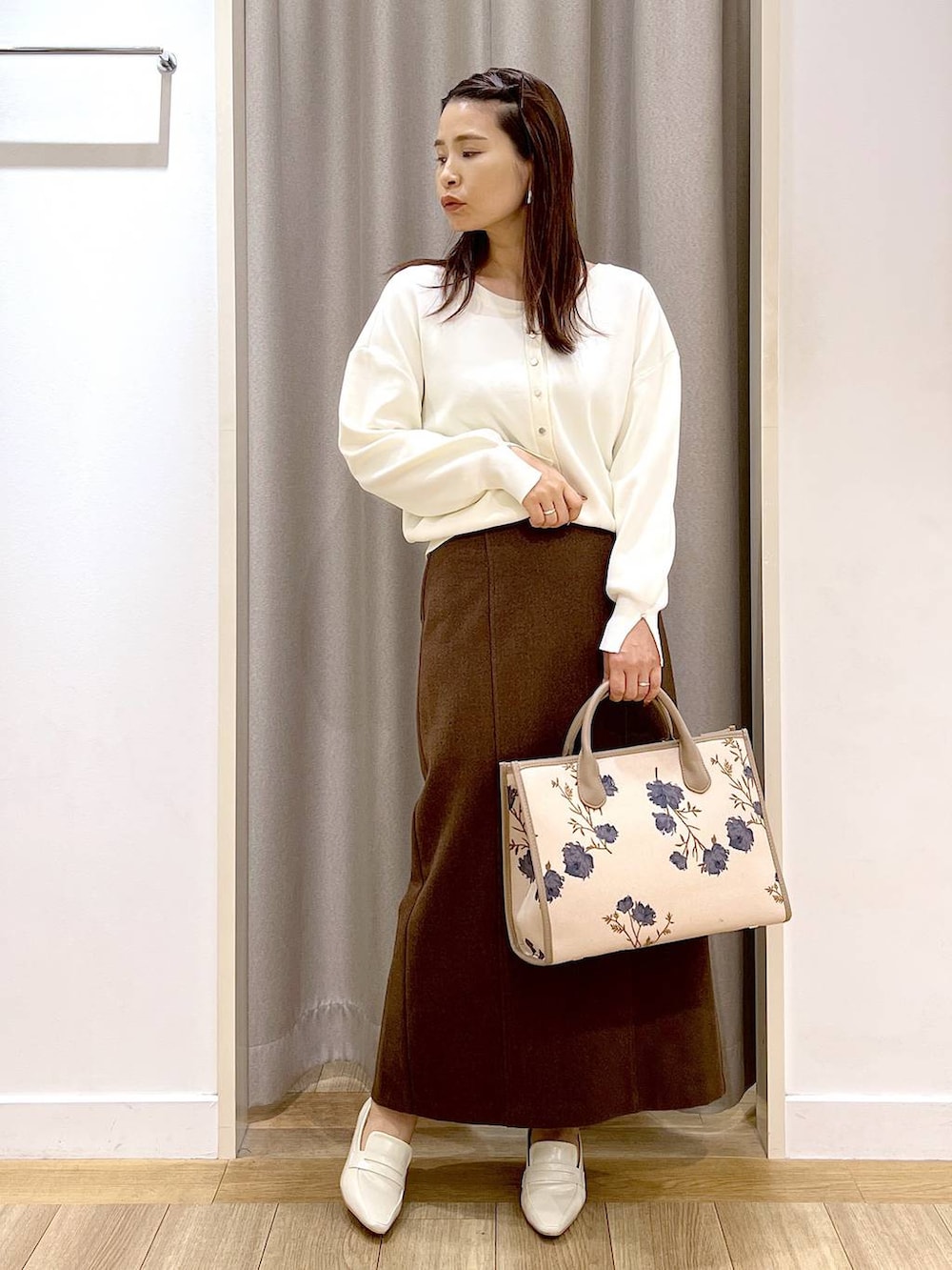 ベージュ系のローファー、ホワイト系のカーディガン/ボレロ、ブラウン系のスカートを着用したレディースの秋コーディネートの3枚目の写真