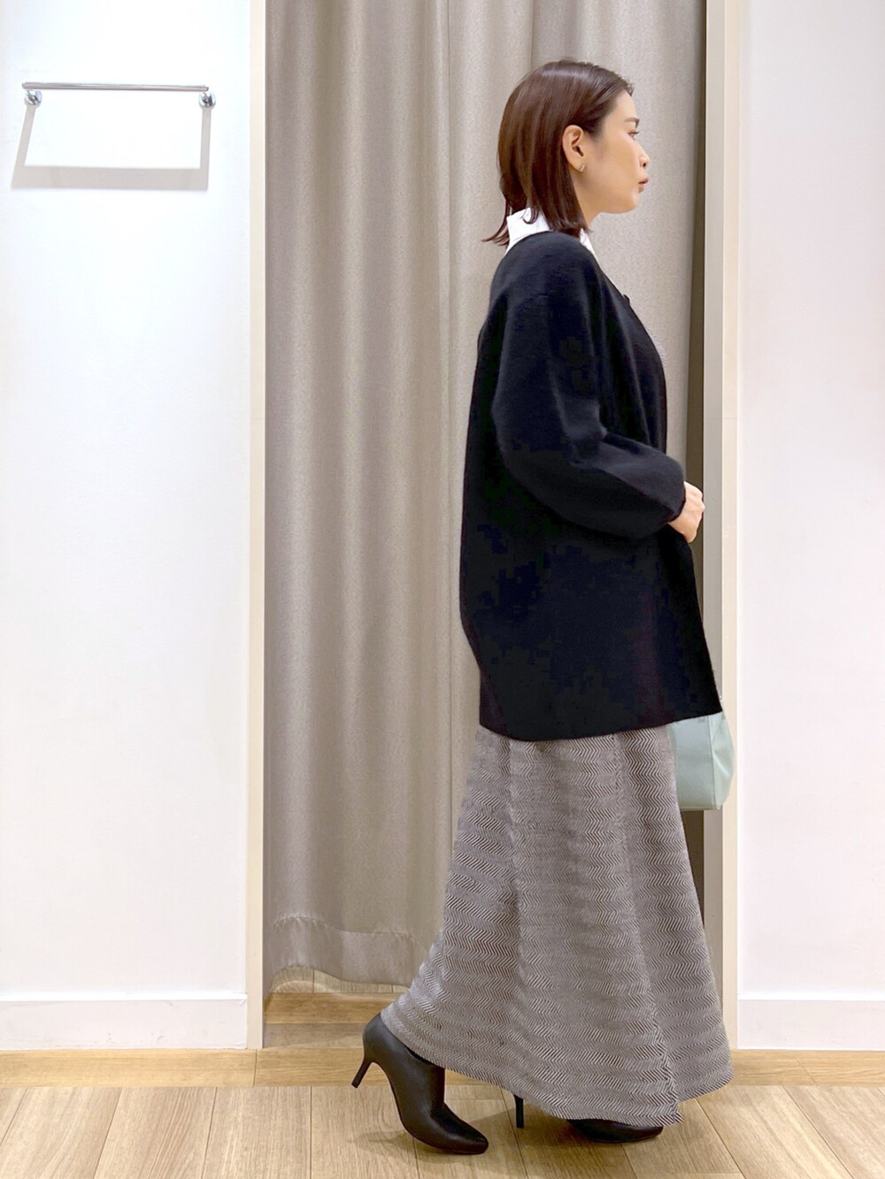 ブラック系のカーディガン/ボレロ、ブラック系のワンピース、グリーン系のショルダーバッグを着用したレディースの冬コーディネートの2枚目の写真