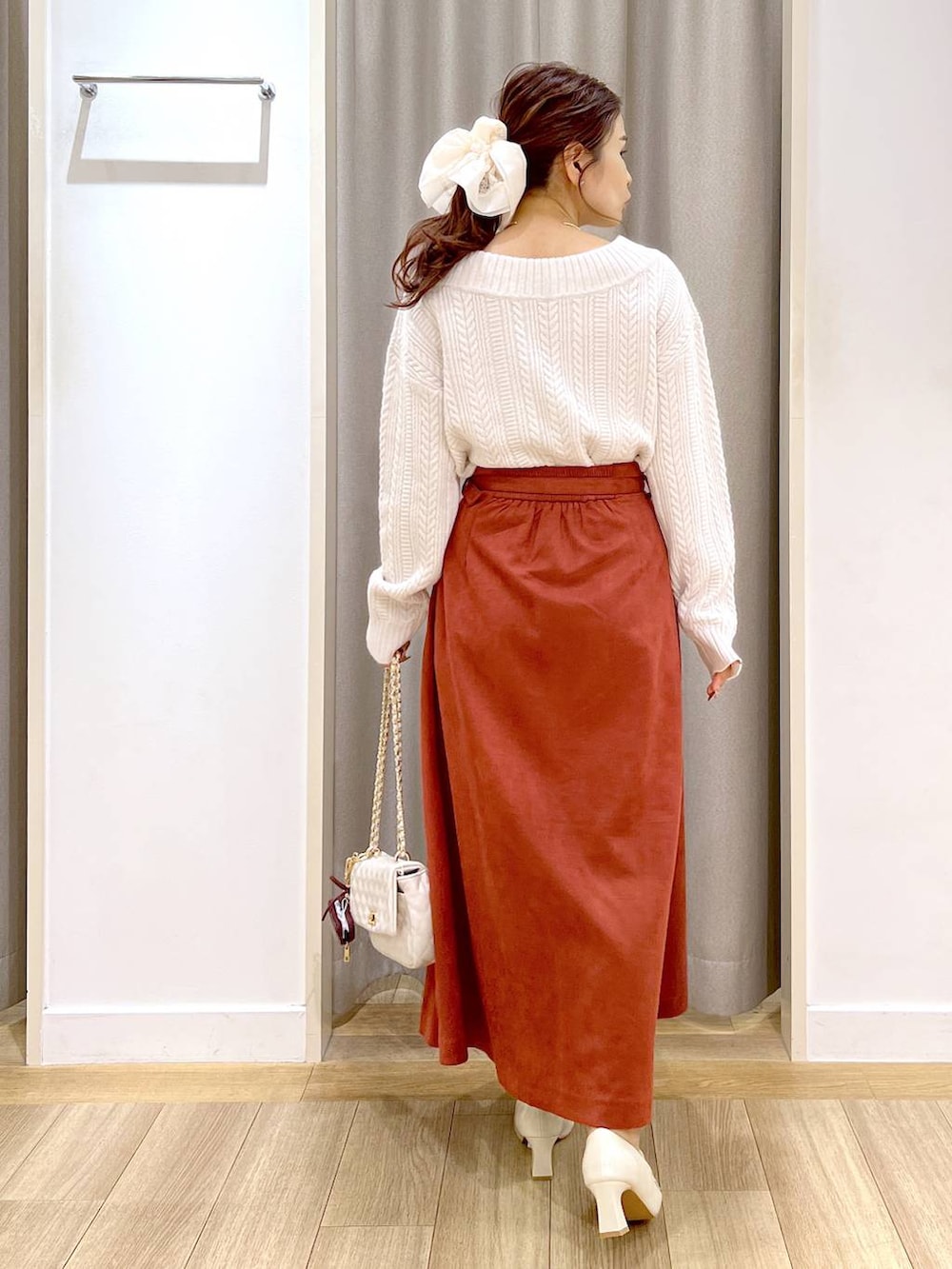 ホワイト系のピーコート、ベージュ系のローファー、レッド系のスカートを着用したレディースの秋コーディネートの9枚目の写真