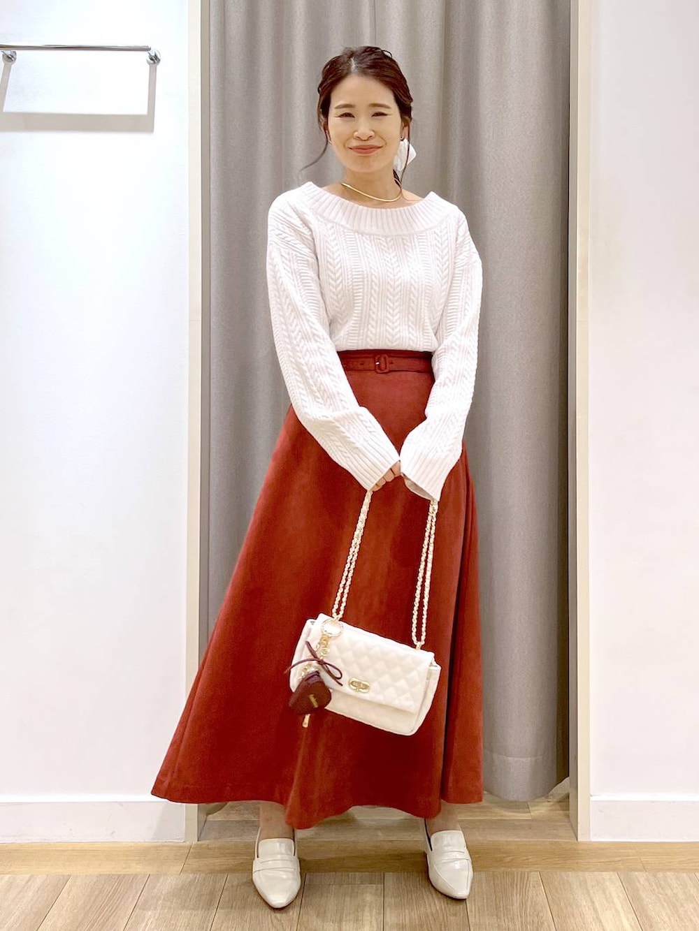 ホワイト系のピーコート、ベージュ系のローファー、レッド系のスカートを着用したレディースの秋コーディネートの8枚目の写真