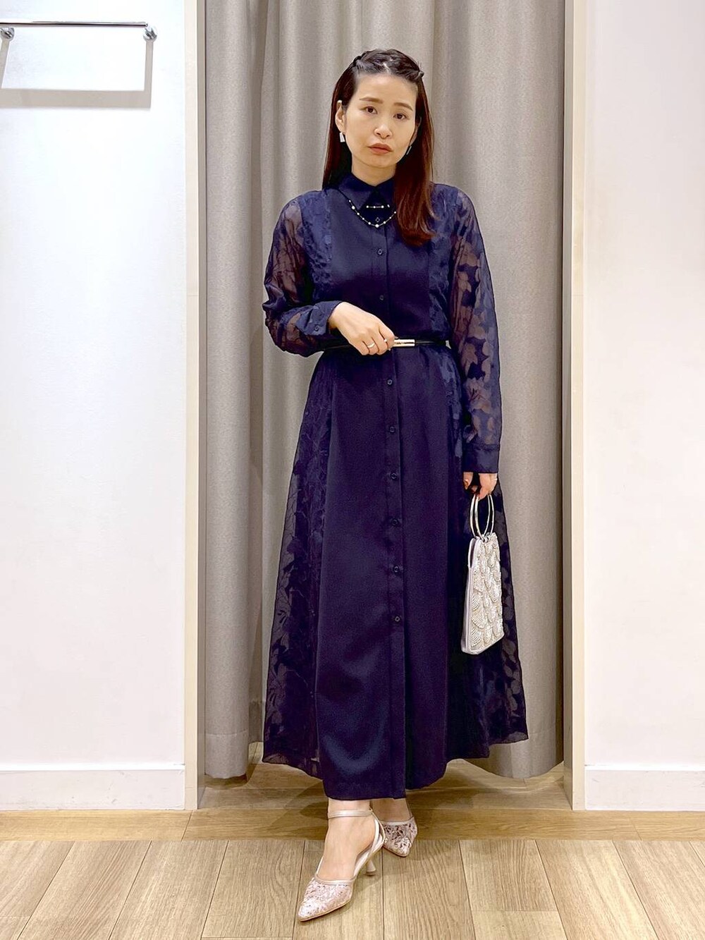 グレー系のショルダーバッグ、ベージュ系のパンプス、ブルー系のワンピースを着用したレディースの秋コーディネートの6枚目の写真