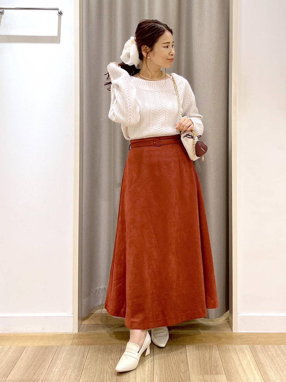 ホワイト系のピーコート、ベージュ系のローファー、レッド系のスカートを着用したレディースの秋コーディネートの7枚目の写真