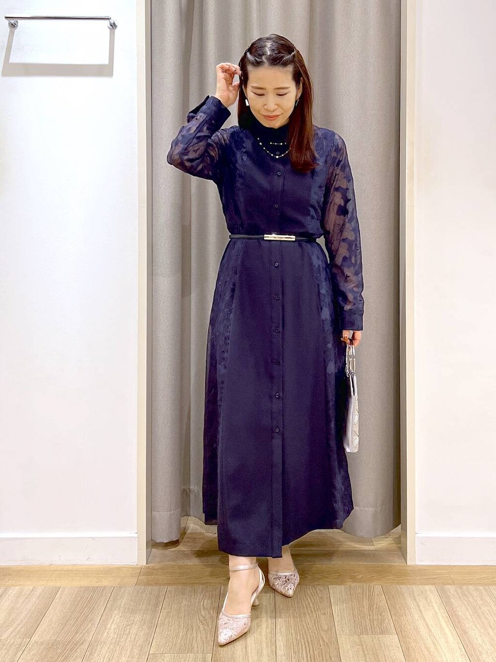 グレー系のショルダーバッグ、ベージュ系のパンプス、ブルー系のワンピースを着用したレディースの秋コーディネートの5枚目の写真