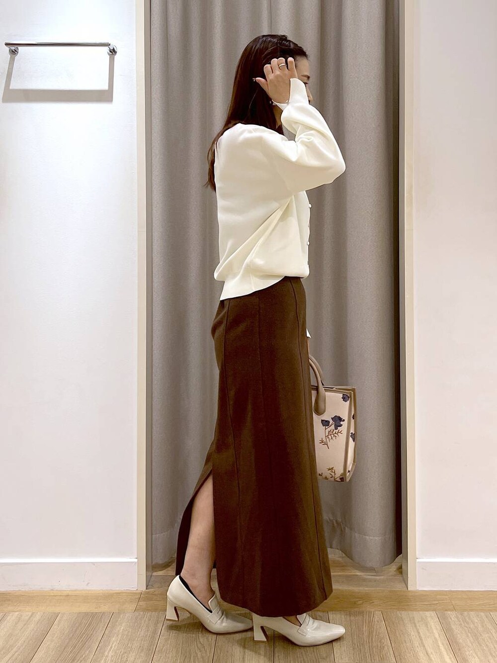 ベージュ系のローファー、ホワイト系のカーディガン/ボレロ、ブラウン系のスカートを着用したレディースの秋コーディネートの8枚目の写真