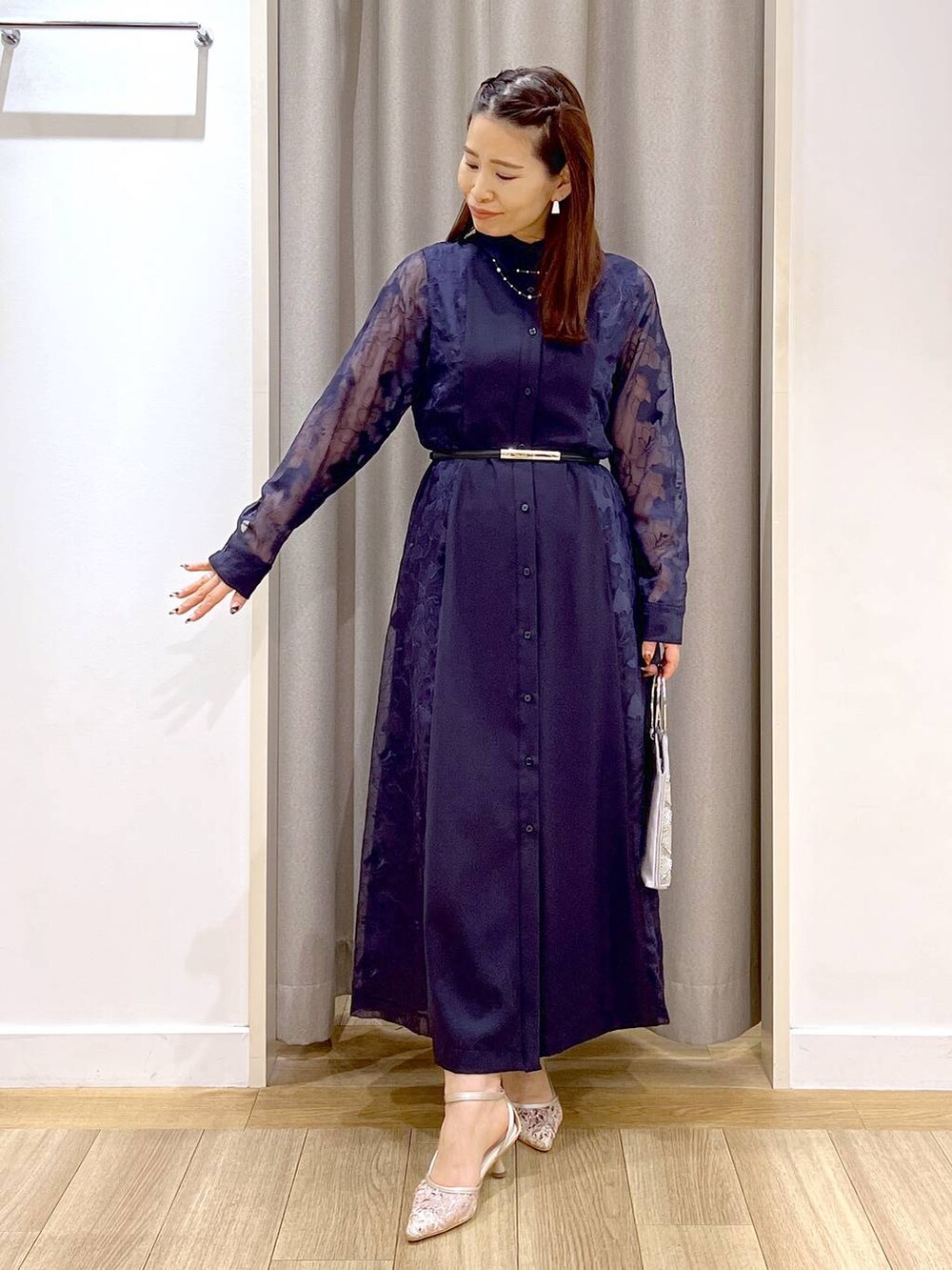グレー系のショルダーバッグ、ベージュ系のパンプス、ブルー系のワンピースを着用したレディースの秋コーディネートの7枚目の写真