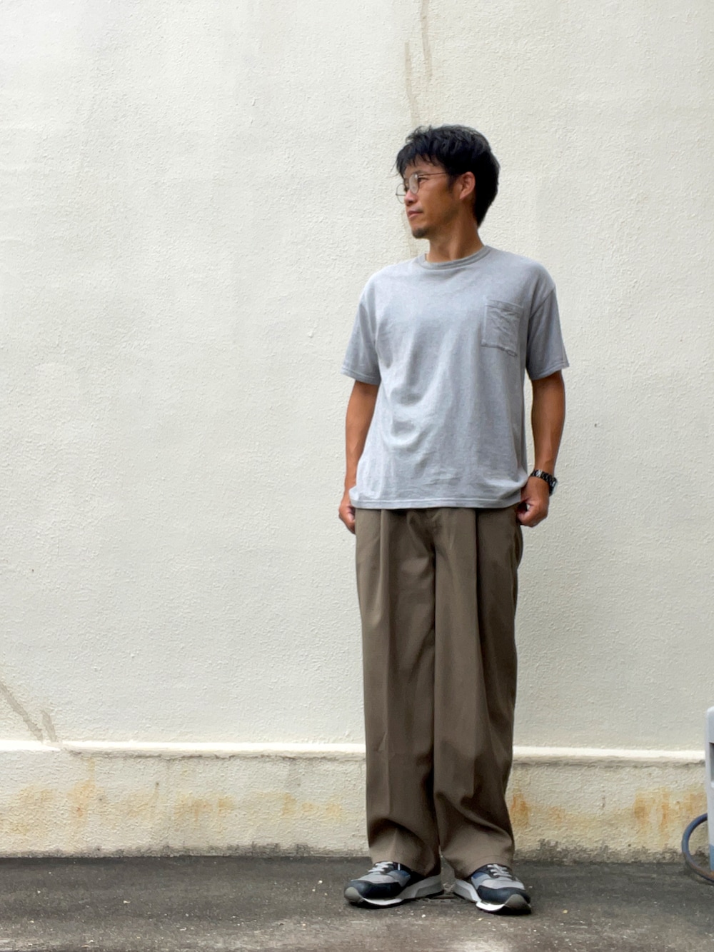 グレー系のTシャツ/カットソー、ブラウン系のスラックス、グレー系のスニーカーを着用したメンズの秋コーディネートの2枚目の写真