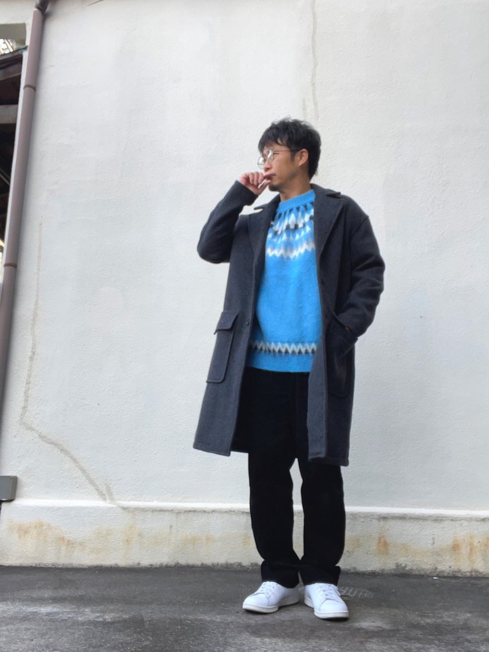 ブルー系のニット/セーター、ブラック系のその他パンツ、ホワイト系のスニーカーを着用したメンズの冬コーディネートの2枚目の写真