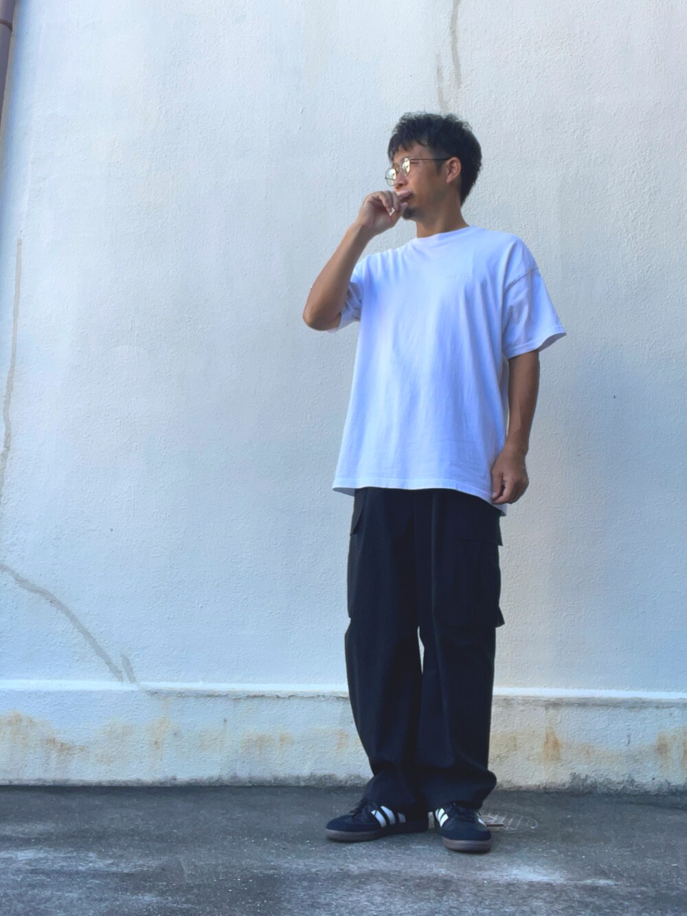 ブラック系のカーゴパンツ、ホワイト系のTシャツ/カットソー、ブラック系のスニーカーを着用したメンズの秋コーディネートの2枚目の写真