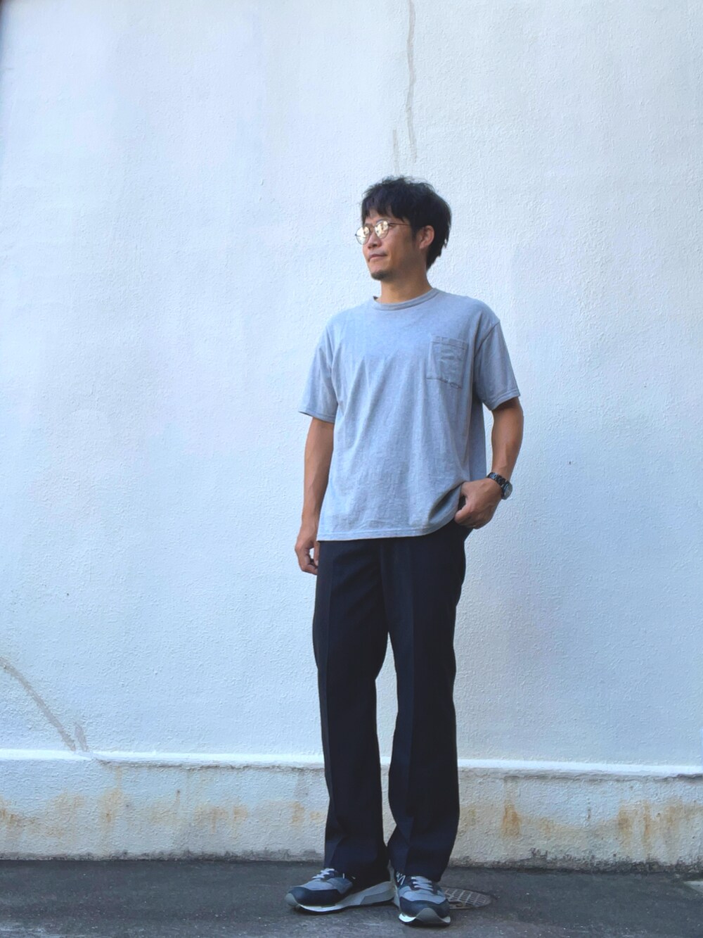 グレー系のTシャツ/カットソー、ブラック系のスラックス、グレー系のスニーカーを着用したメンズの夏コーディネートの2枚目の写真