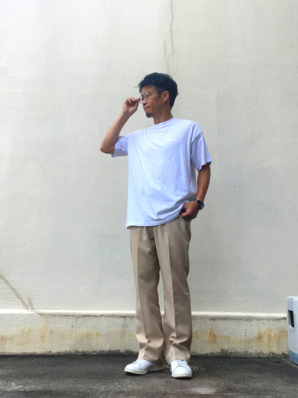ホワイト系のTシャツ/カットソー、ベージュ系のスラックス、ホワイト系のスニーカーを着用したメンズの夏コーディネートの2枚目の写真