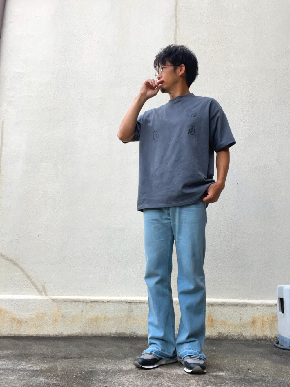 グレー系のTシャツ/カットソー、ブルー系のデニムパンツ、グレー系のスニーカーを着用したメンズの夏コーディネートの2枚目の写真