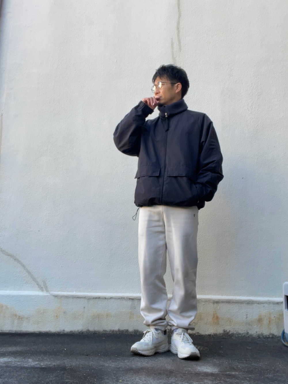 ブラック系のブルゾン、ベージュ系のニット/セーター、ベージュ系のスウェットパンツを着用したメンズの冬コーディネートの2枚目の写真