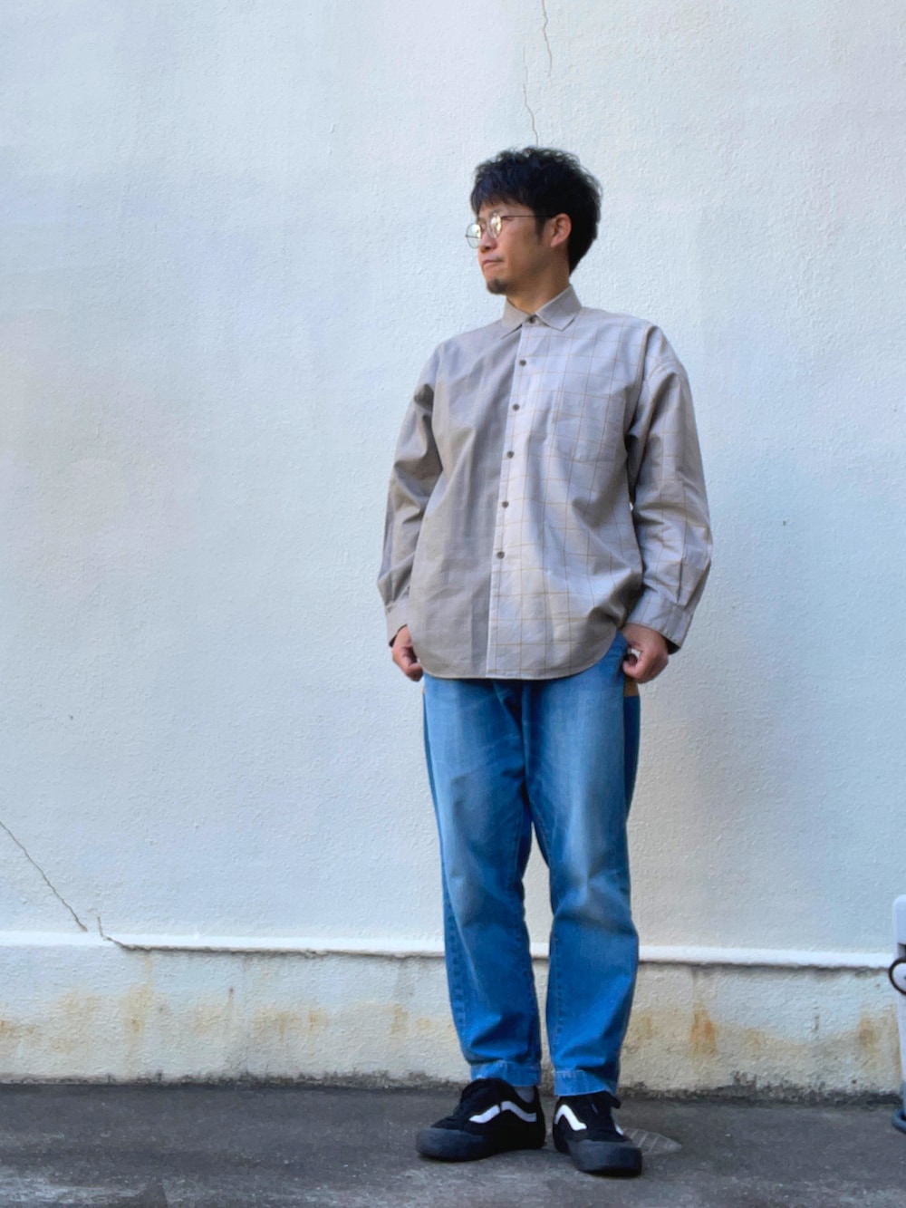 ベージュ系のカーディガン/ボレロ、ベージュ系のシャツ/ブラウス、ブルー系のデニムパンツを着用したメンズの春コーディネートの2枚目の写真