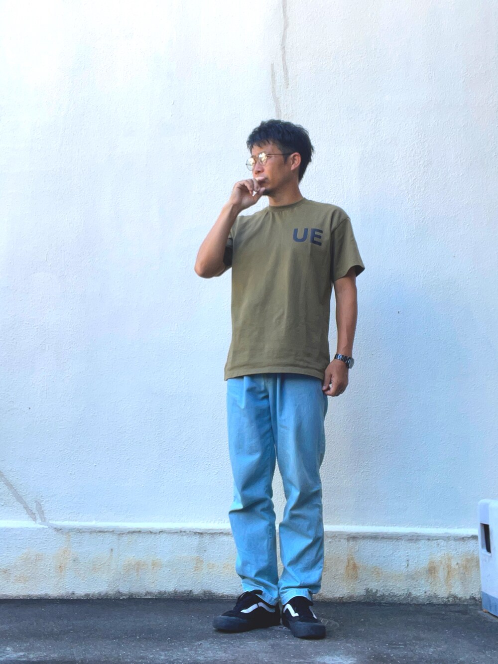 グリーン系のTシャツ/カットソー、ブルー系のデニムパンツ、ブラック系のスニーカーを着用したメンズの夏コーディネートの2枚目の写真