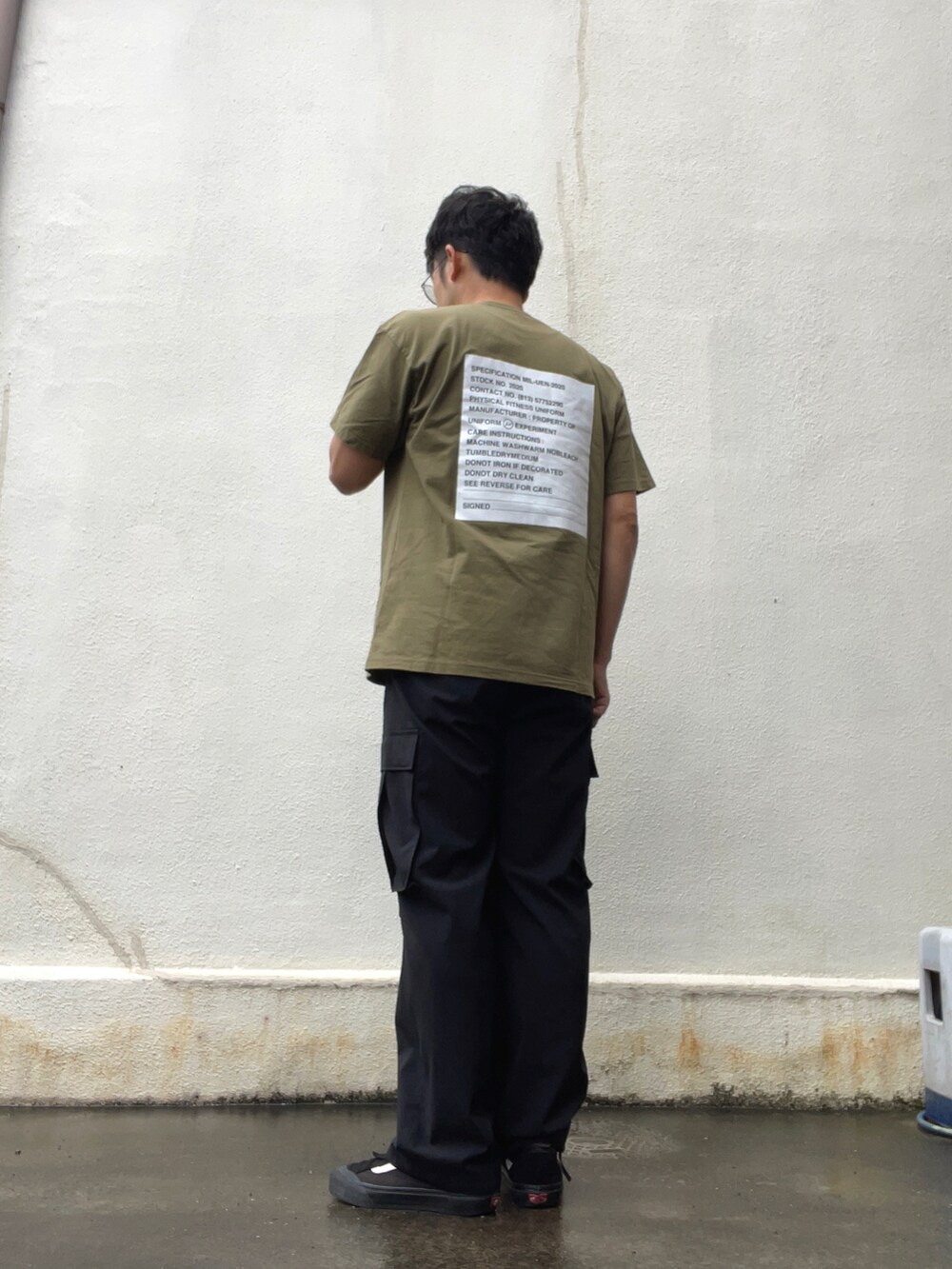 ブラック系のカーゴパンツ、グリーン系のTシャツ/カットソー、ブラック系のスニーカーを着用したメンズの夏コーディネートの2枚目の写真