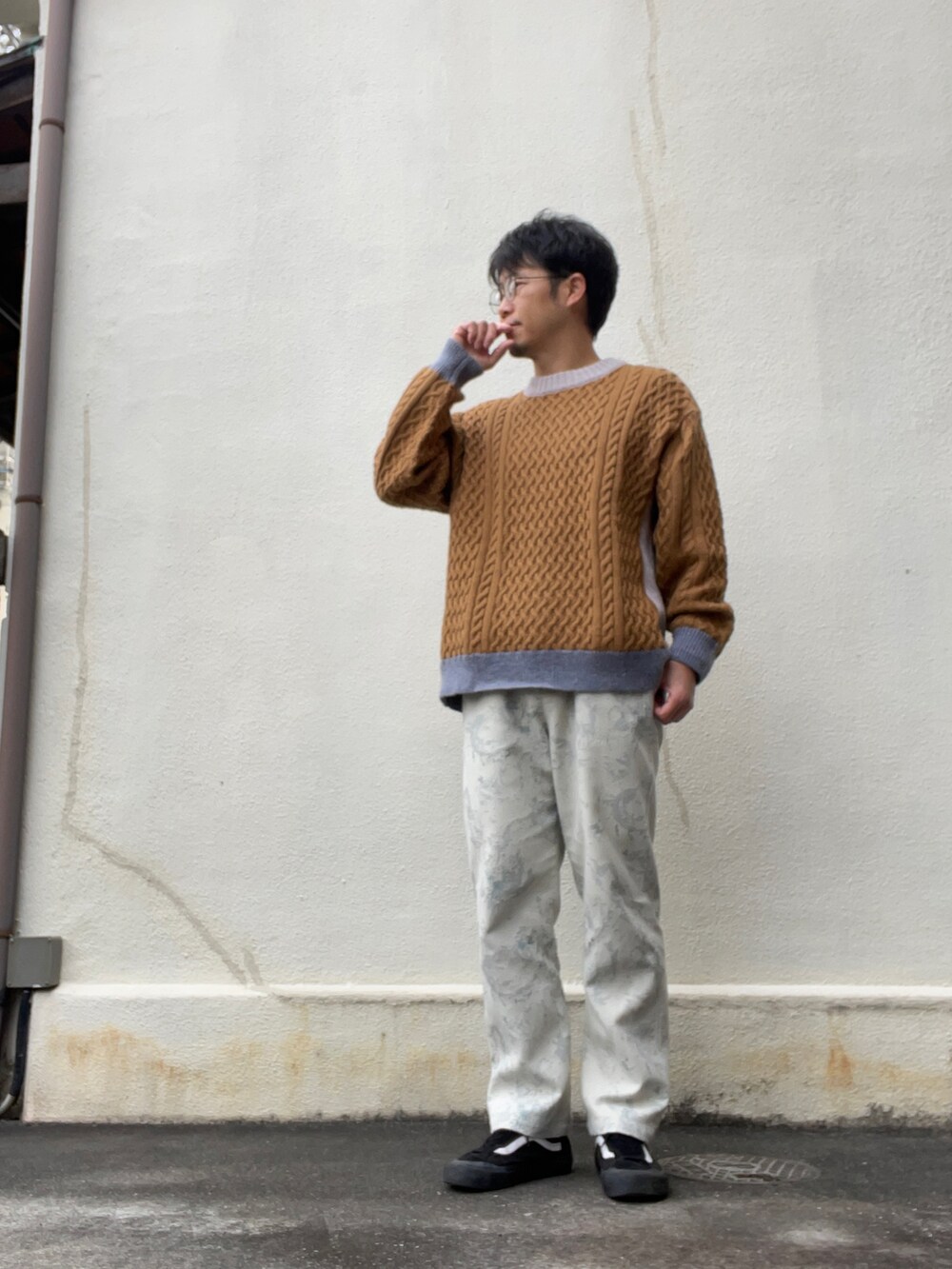 ブラック系のダウンジャケット/コート、ベージュ系のニット/セーター、ホワイト系のその他パンツを着用したメンズの冬コーディネートの2枚目の写真