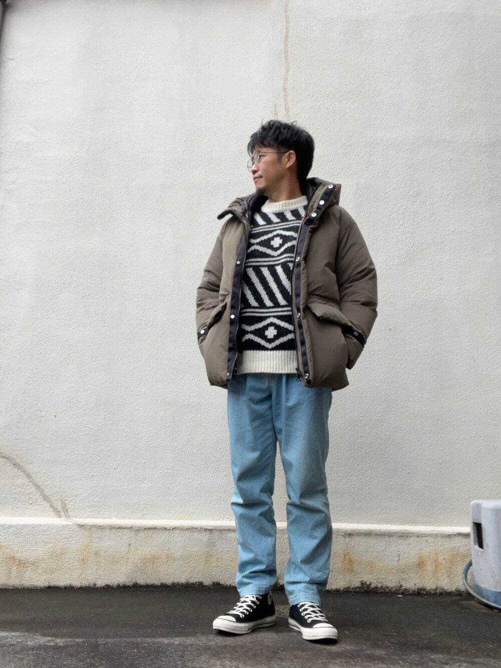 ホワイト系のニット/セーター、ブルー系のデニムパンツ、ブラック系のスニーカーを着用したメンズの冬コーディネートの2枚目の写真