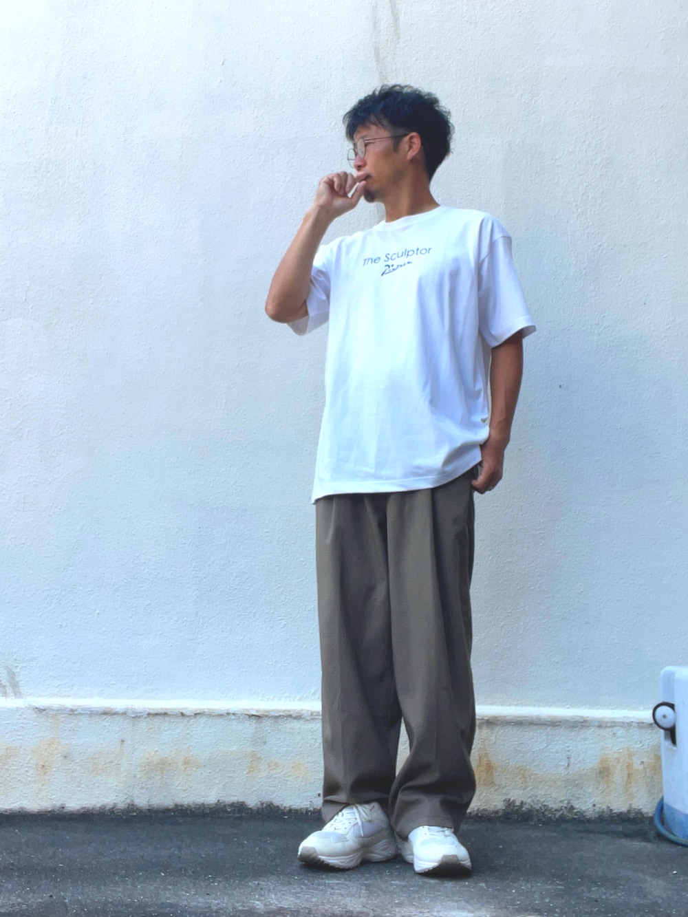 ホワイト系のTシャツ/カットソー、ブラウン系のスラックス、ホワイト系のスニーカーを着用したメンズの夏コーディネートの2枚目の写真