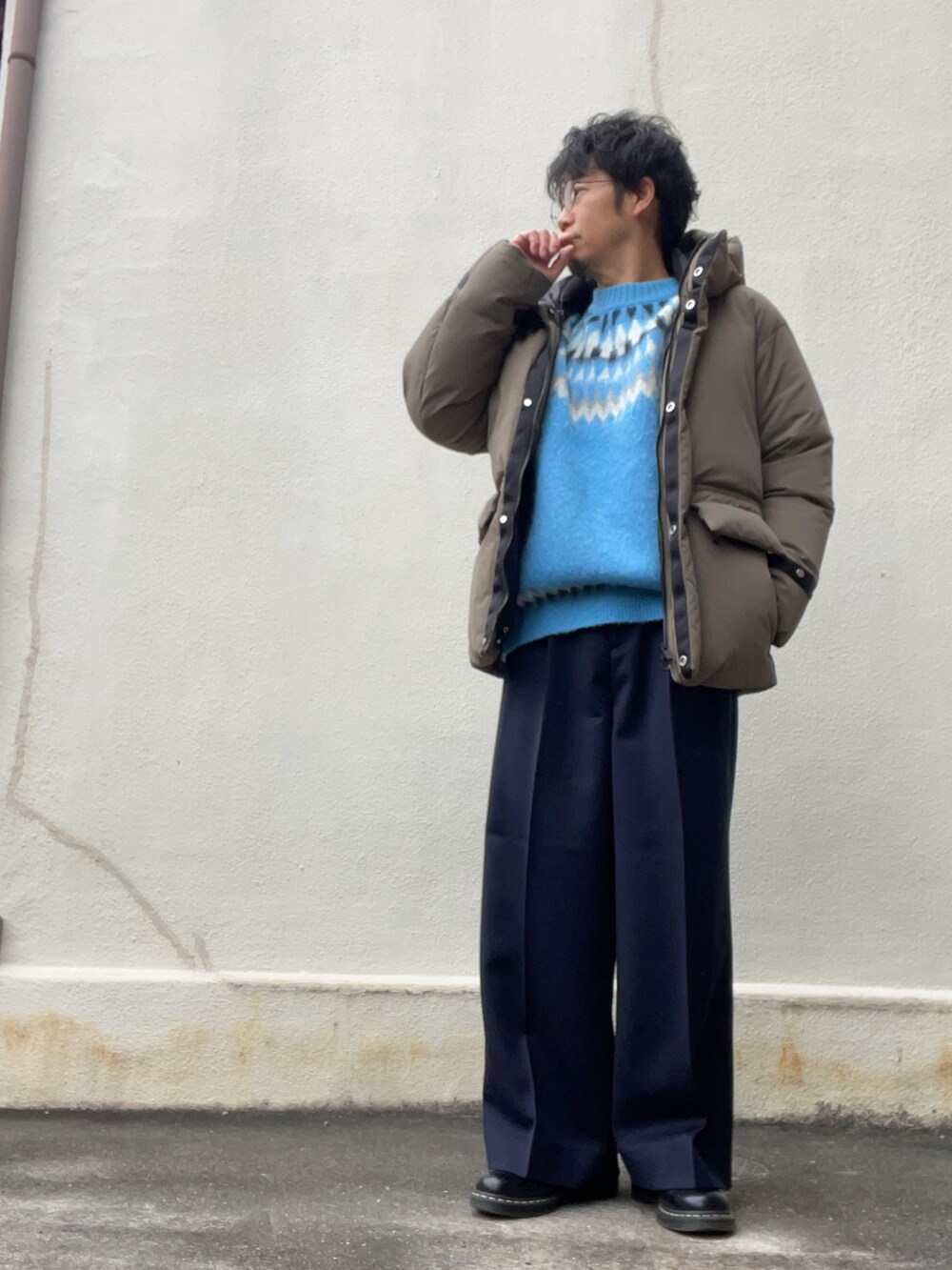 ブルー系のニット/セーター、ブルー系のスラックス、ホワイト系のブーツを着用したメンズの冬コーディネートの2枚目の写真