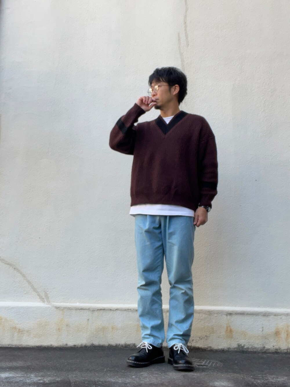 ベージュ系のダウンジャケット/コート、レッド系のニット/セーター、ブルー系のデニムパンツを着用したメンズの冬コーディネートの2枚目の写真