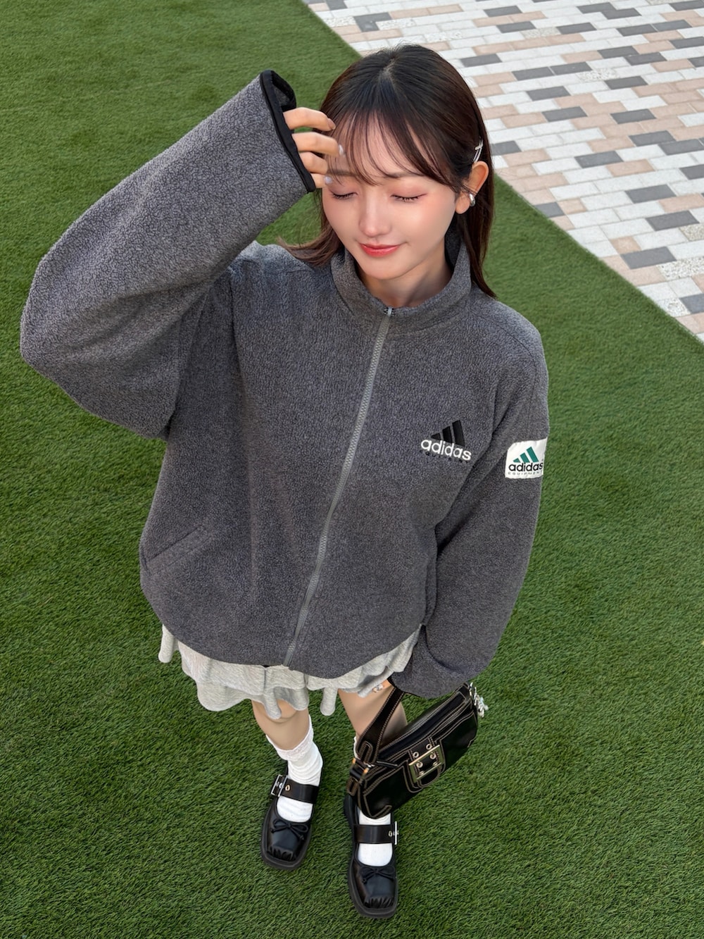 グレー系のその他アウター、グレー系のスカート、ブラック系のパンプスを着用したレディースの春コーディネートの2枚目の写真