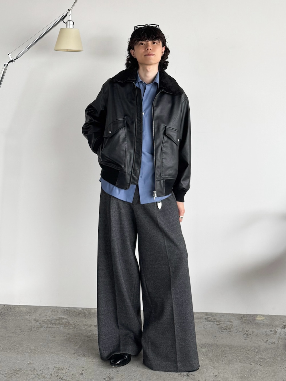 ブラック系のブルゾン、ブルー系のシャツ/ブラウス、グレー系のスラックスを着用したメンズの秋コーディネートの5枚目の写真