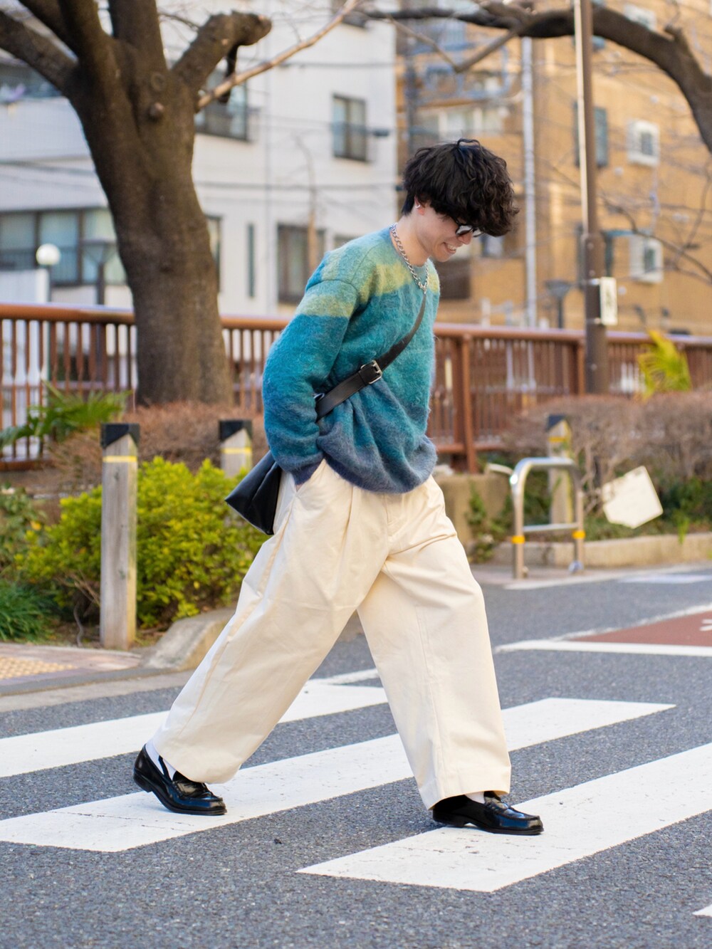 ブルー系のニット/セーター、ブラック系のショルダーバッグ、ホワイト系のその他パンツを着用したメンズの冬コーディネートの2枚目の写真