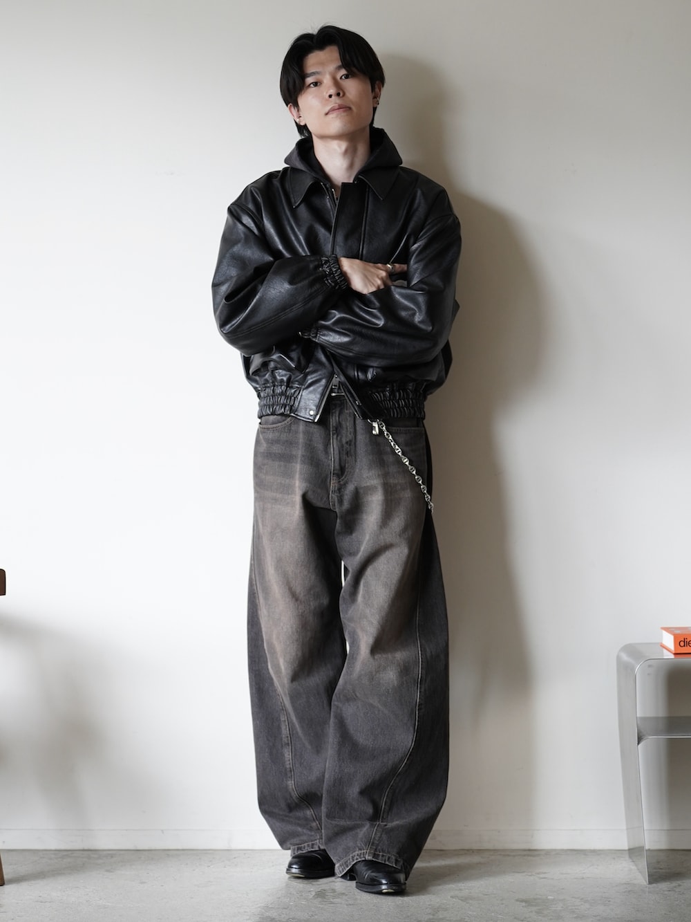 ブラック系のデニムパンツ、ブラック系のローファー、ブラック系のパーカーを着用したメンズの秋コーディネートの2枚目の写真