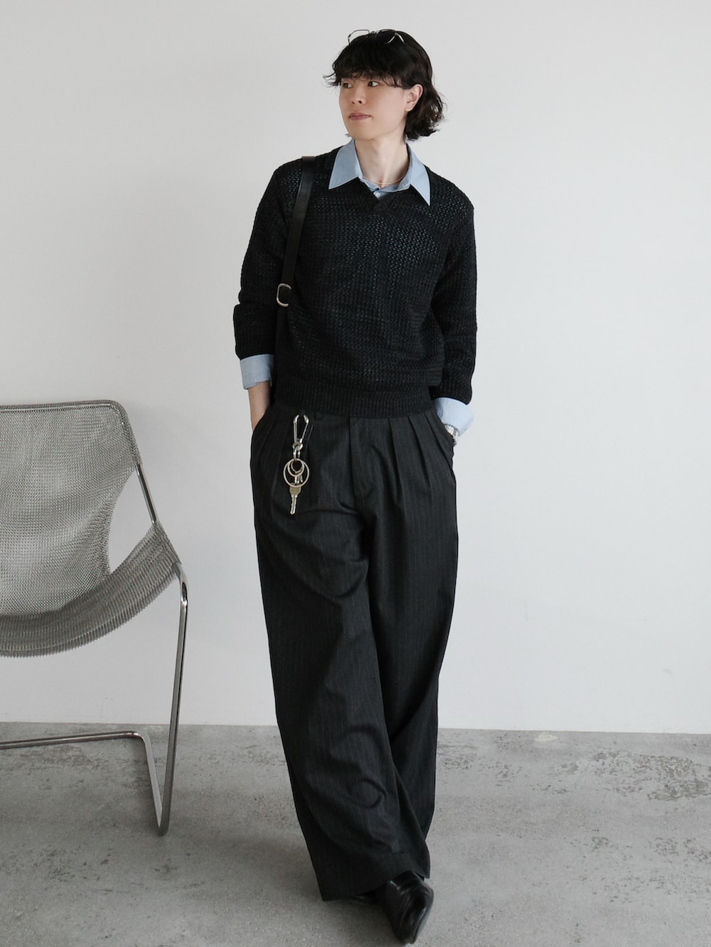 グレー系のニット/セーター、ブルー系のシャツ/ブラウス、ブラック系のショルダーバッグを着用したメンズの冬コーディネートの2枚目の写真